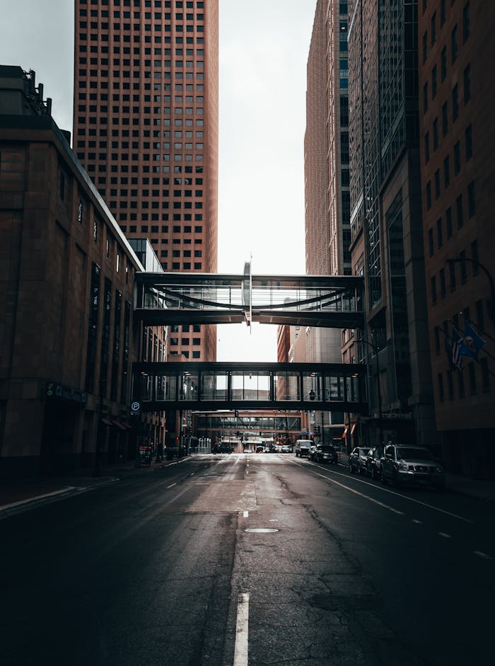 Cars Parked on Side of the Road in Between High Rise Buildings